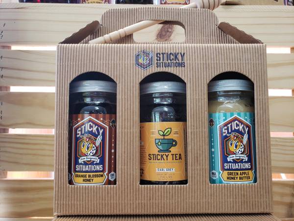 Earl Grey Tea, Green Apple Honey Butter, Orange Blossom in a box with Sticky Situations Logo and a Honey Dipper on top
