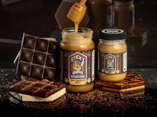 sticky situations 8 oz dark chocolate honey on left, 4 oz jar on right. Dark chocolate bar on far left.