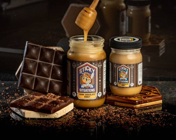 sticky situations 8 oz dark chocolate honey on left, 4 oz jar on right. Dark chocolate bar on far left.